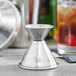 An American Metalcraft stainless steel jigger on a table.