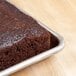 A close up of a square cake baked with a Baker's Mark half-size sheet pan extender on a table.