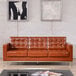 A brown Flash Furniture Hercules Lacey leather sofa with buttons in a lounge area.