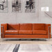 A brown leather Flash Furniture Hercules Regal sofa with metal legs in a lounge area.