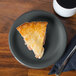A piece of pie on a Fiesta® Slate China Appetizer Plate next to a mug of coffee.