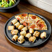 A pizza and rolls on a Fiesta® Slate China plate.