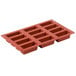 A red silicone Matfer Bourgeat mini cake mold with 12 compartments.