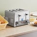 An Avantco commercial toaster with four slots on a counter with bread.