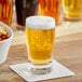 An Acopa pub beer tasting glass full of beer on a coaster.