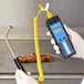 A person holding a Cooper-Atkins AquaTuff thermometer with a yellow spiral cable.