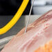A Cooper-Atkins Type-K needle probe with a coiled cable inserted into a piece of meat.