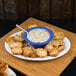 A Carlisle white melamine oval platter with bread, dip, and chips on a table.
