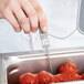 A person uses a Taylor Type-K probe to check the temperature of a meatball.