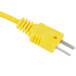 A close up of a yellow plug with a metal tip.