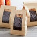 A group of brown Choice paper bags with coffee beans in them.