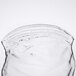 An American Metalcraft glass of clear liquid with a white background.