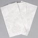 A stack of white Hoffmaster Linen-Like guest towels with a floral pattern.