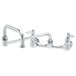 A chrome T&S wall mounted pantry faucet with two handles and an 18" double-jointed swing nozzle.