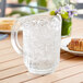 A Cambro clear plastic pitcher filled with ice water on a table.