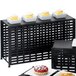 A black metal Cal-Mil rectangular lattice riser holding cupcakes and muffins on a table.