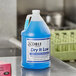 A blue bottle of Noble Chemical Dry It Low Rinse Aid on a counter.