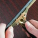 A person using a Unger brass channel to clean a window.