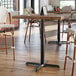 A Lancaster Table & Seating black bar height table base with a black pole.