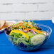 A clear Fineline plastic bowl filled with salad and a yellow pepper.