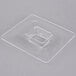 A clear square plastic lid with a square hole in it.