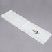A white Hoffmaster guest towel with a floral design in white.