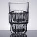 A Libbey stackable rocks glass with a patterned design on a table.