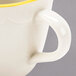 A CAC ivory china espresso cup with a gold rim.