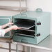 A woman using a Cambro front loading tray carrier to hold food.