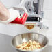 A person using a Vollrath Redco French Fry Cutter to slice french fries.