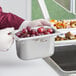 A silver Vollrath Super Pan 3 with grapes in it.