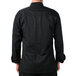A man wearing a black Mercer Culinary chef jacket with knot buttons.