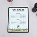 An 8 1/2" x 11" seafood menu with a wine glass on a white surface.