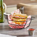 A sandwich and fries in an American Metalcraft black wire basket on a table.