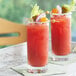 Two glasses of Dei Fratelli Prima Qualita Vegetable Juice with pickles and onions on a table.