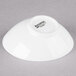 An Arcoroc Ludico porcelain bowl with white text on a white background.