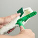 A hand holding a green Unger Original StripWasher Sleeve