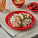 A Thunder Group Pure Red melamine plate with rice and berries on a wood table.