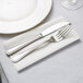 A fork and knife on a Hoffmaster white linen-like napkin.