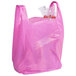 A magenta plastic T-shirt bag with a plastic bag inside.