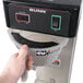 A hand holding a Bunn 36700.0030 3 Gallon Iced Tea Brewer.