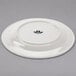 A white plate with an embossed bow tie logo.