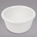 A white Thunder Group fluted bone melamine ramekin on a gray surface.