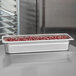 A Choice stainless steel steam table pan filled with beans on a table.