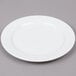 An Arcoroc white porcelain salad plate with a small rim.