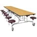 A National Public Seating mobile cafeteria table with stools on one side.