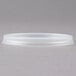 A white plastic Cambro lid with a straw slot on a gray surface.