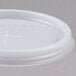 A close-up of a translucent plastic lid with a straw slot.