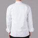 A man wearing a white Mercer Culinary long sleeve chef jacket.