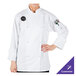 A woman wearing a Mercer Culinary white long sleeve chef jacket with cloth knot buttons.